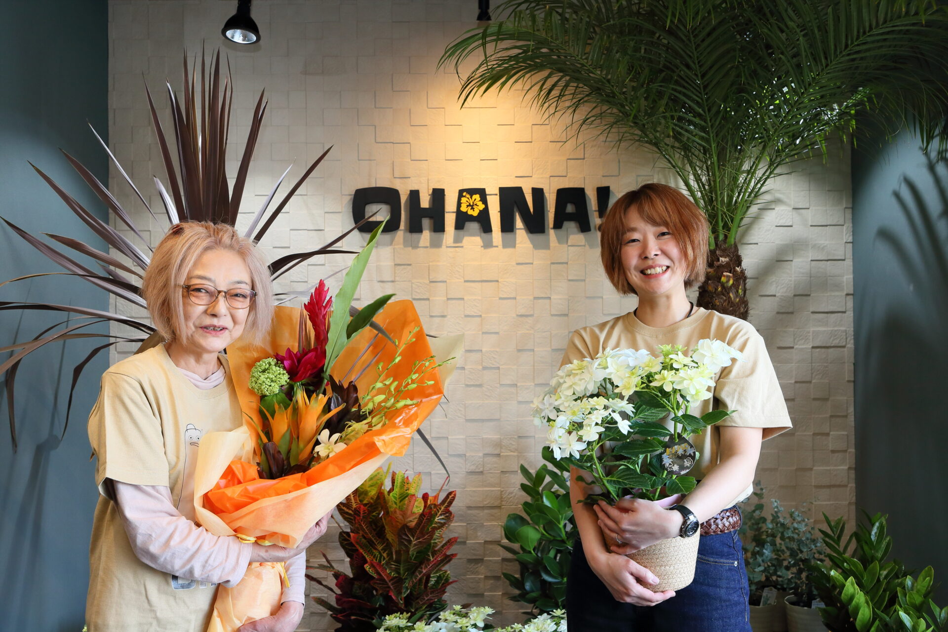 スタッフの2名が看板を前に立っている様子